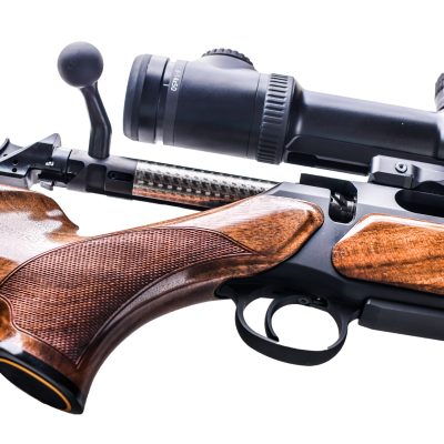 Hunting rifle large-caliber detail or close up with optical viewfinder isolated on white background. Telescopic sight on gun.