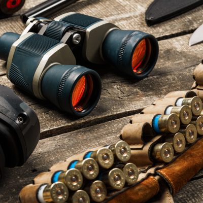 Hunting equipment binoculars on wooden background close up photo